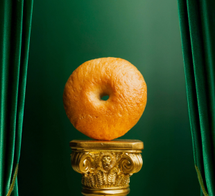 bagel on gold podium with green background